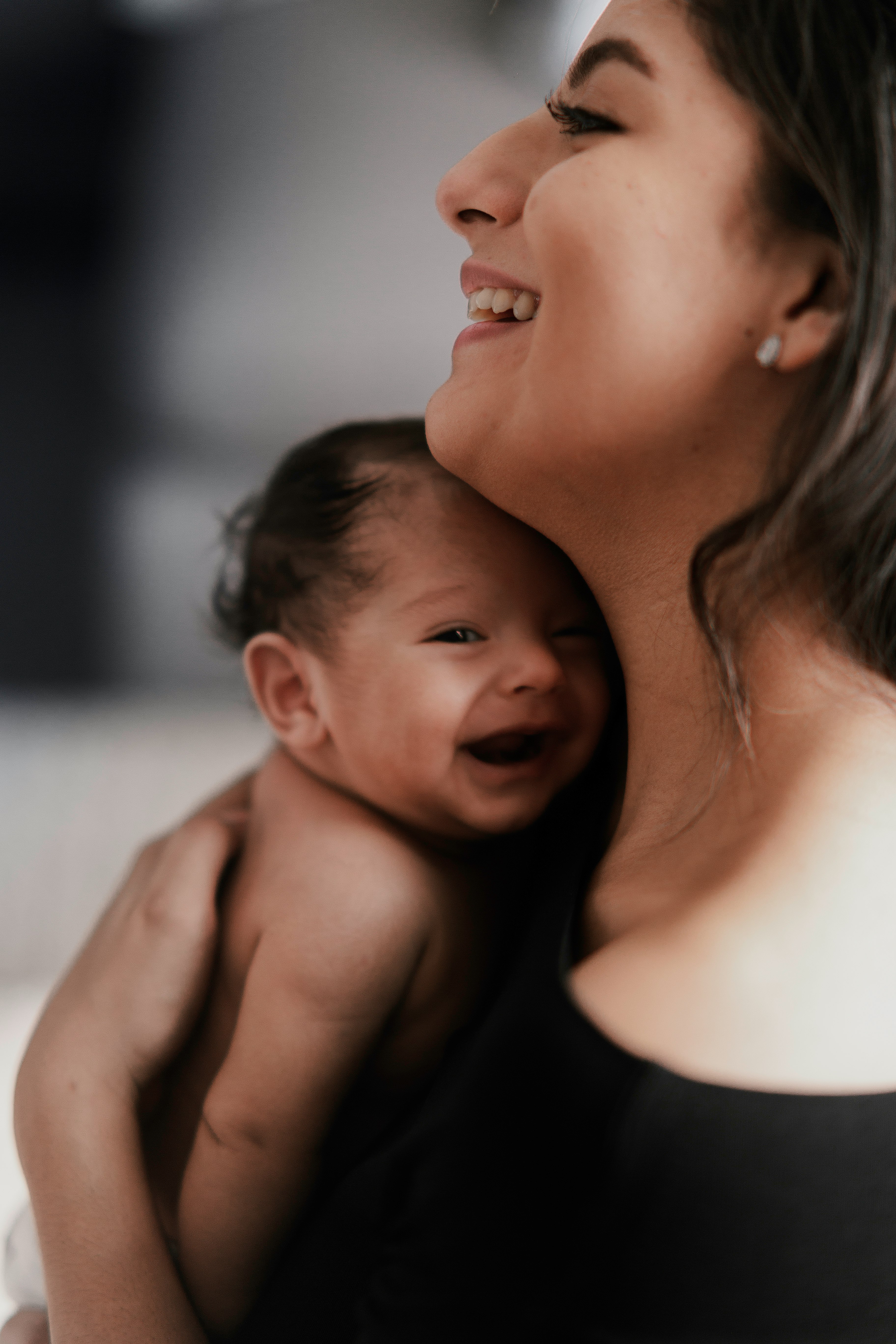 woman carrying smiling baby